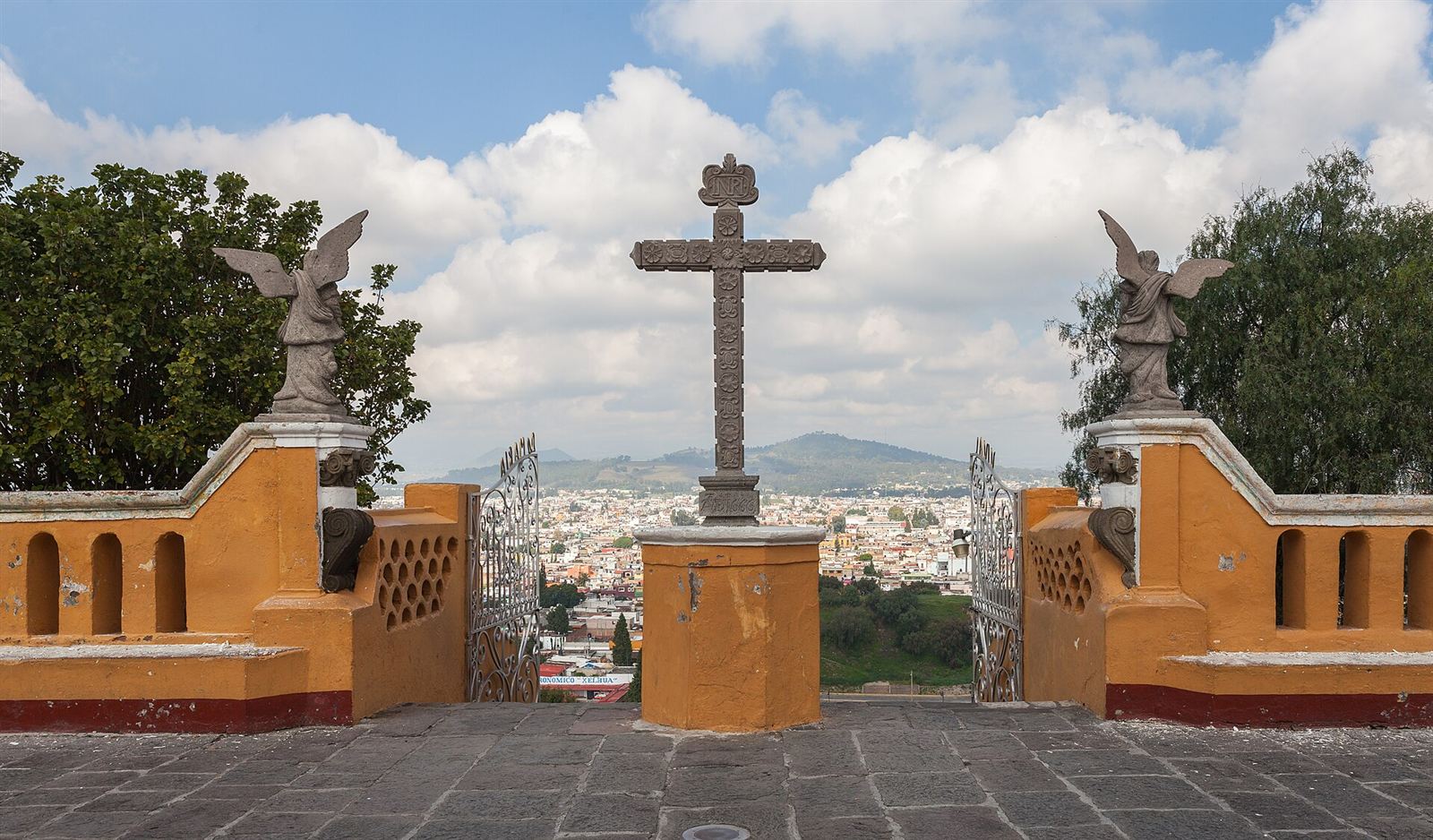 Atrio del santuario de Nuestra Señora de los Remedios, con su cruz de cantera y Cholula al fondo
